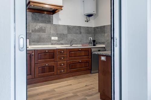 a kitchen with wooden cabinets and a sink at Guest House Fantaccini con Piscina in Pelago