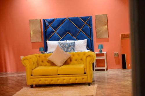 a yellow couch with a blue headboard in a room at Kneizenberg Boutique Lodge & Spa in Louis Trichardt