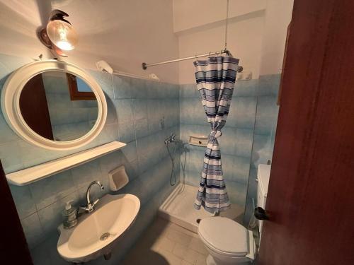 a bathroom with a sink and a toilet and a mirror at Poseidonio Apartments in Poseidónion