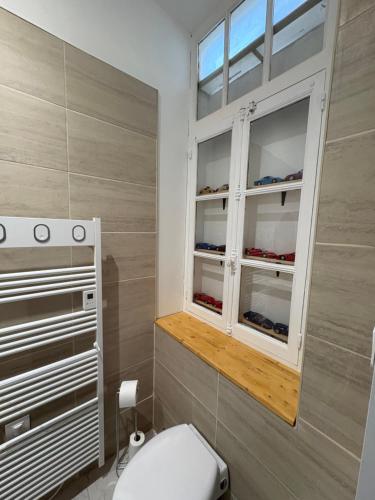 a bathroom with a toilet and a window at Chez Rémi in Écommoy