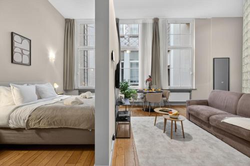 a bedroom and a living room with a bed and a couch at Maison Lombard by Reside in Brussels