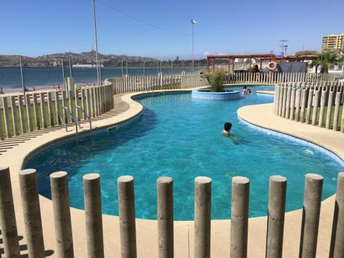 een persoon die zwemt in een zwembad naast een strand bij Apartment Joet La Herradura in Coquimbo