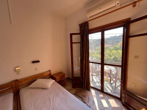 a bedroom with a bed and a large window at Poseidonio Apartments in Poseidónion