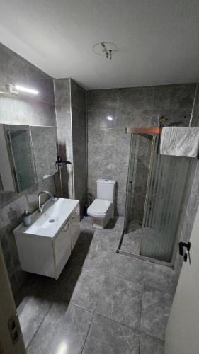 a bathroom with a sink and a shower and a toilet at Elizim Otel in İzmir