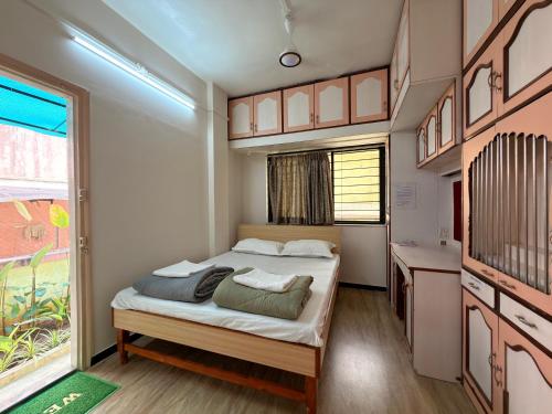 a small bedroom with a bed and a window at My second home at Nashik in Nashik