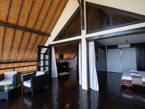 a bedroom with a bed and a chair in a room at Villa Bossi Bali at Tanguwesia in Bubunan