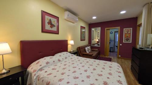 a bedroom with a bed and a desk and a chair at Arouca Passadiços Alojamento & Jacuzzi - SPA in Arouca
