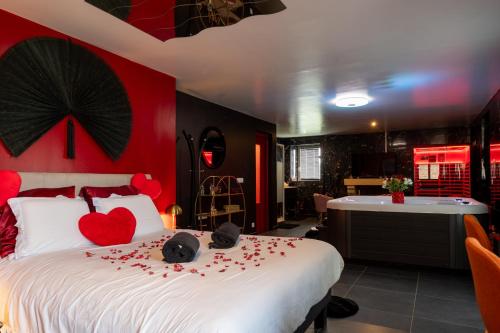 a bedroom with a bed with red hearts on it at Le Cocon secret - Sauna - Jacuzzi in Quimperlé