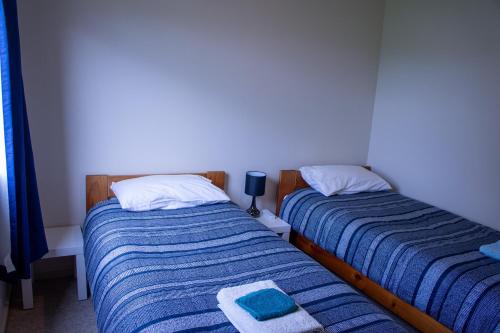 two beds sitting next to each other in a bedroom at Minffordd Cottage in Feilding