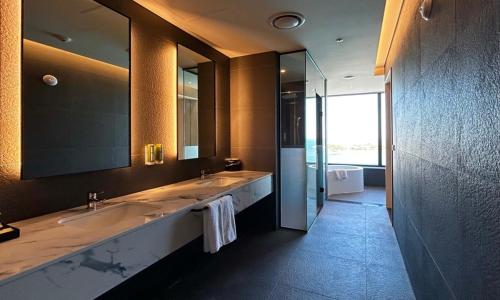 a bathroom with two sinks and a large mirror at Ulsan Tanibay Hotel & Wedding in Ulsan