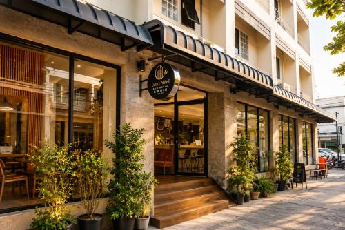 a store front of a building with potted plants at Collection O Luna Hotel Pattaya in Pattaya