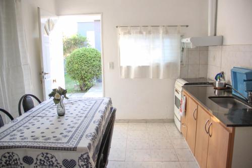 una cocina con una mesa con un jarrón de flores. en Casa en Balneario Sol y Rio en Villa Carlos Paz