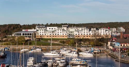 a large white building with boats docked in a marina at Scandic Laholmen in Strömstad