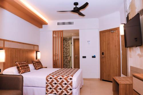a hotel room with a bed and a ceiling fan at Hotel Riu Touareg - All Inclusive in Curral Velho