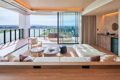 a living room with a white couch and a balcony at FAV LUX Miyazaki in Miyazaki