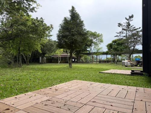 a grassy area with a wooden floor in a park at Mountain Calm Inns in Xiayun