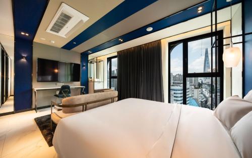 a bedroom with a large white bed and a large window at Hotel the Castle Jamsil Sports Complex in Seoul