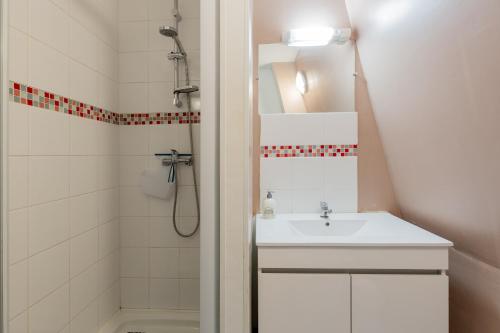 a white bathroom with a sink and a shower at Gîte Escale En Baie De Somme in Saint-Blimont