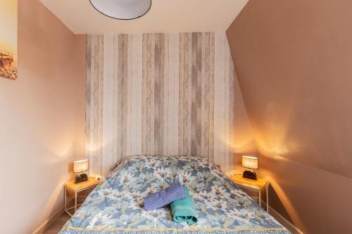 a small bedroom with a bed with two night stands at Gîte Escale En Baie De Somme in Saint-Blimont