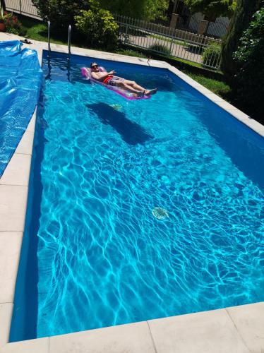 a person laying on a raft in a swimming pool at Aquasol Apartman in Siófok