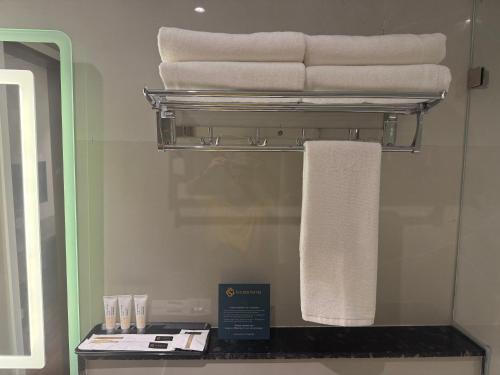 a pile of towels on a shelf in a bathroom at Golden Suites in Bangalore
