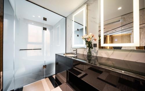 a bathroom with a glass counter with a vase of flowers at Hotel the Castle Jamsil Sports Complex in Seoul