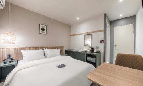 a hotel room with a bed and a desk at Pohang Mansion 6 Hotel in Pohang