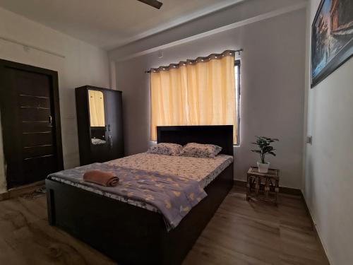 a bedroom with a bed and a window at PnH Stays in Siliguri