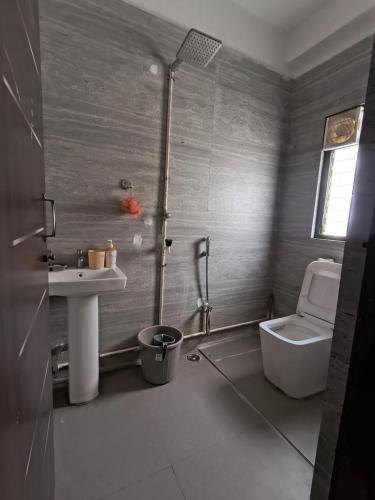 a bathroom with a toilet and a sink at PnH Stays in Siliguri