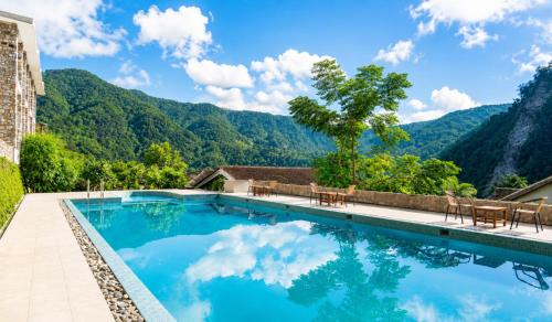 a swimming pool with mountains in the background at Sterling Corbett in Marchula