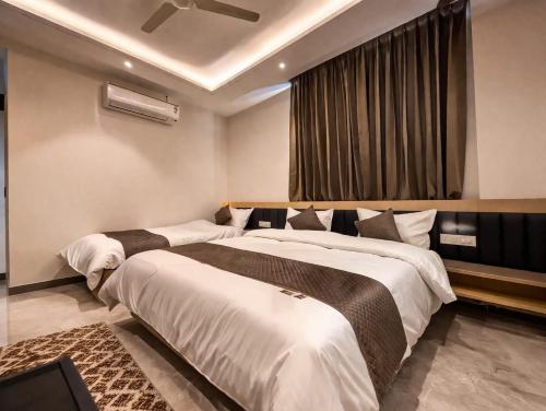 a bedroom with two beds and a window at Maa Trinayani Palace in Katra