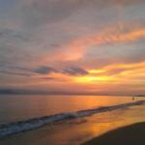 a sunset on the beach with the ocean at Aronis Plaka Naxos in Plaka