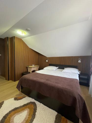 a bedroom with a large bed and a rug at Pensiunea Antonia in Vatra Dornei