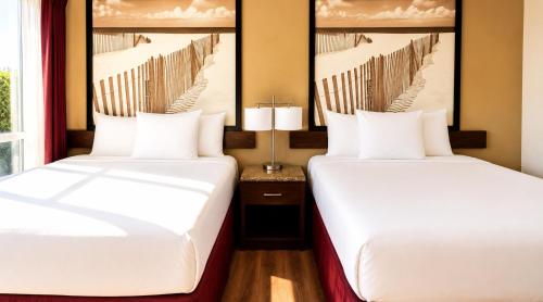 two beds in a room with two windows at Kings Inn Anaheim at The Park & Convention Center in Anaheim