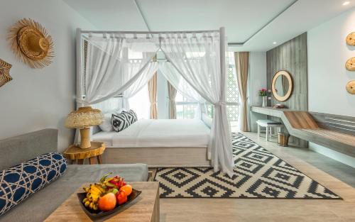 a bedroom with a bed and a table with a bowl of fruit at Villa Sonata Phuket in Chalong 