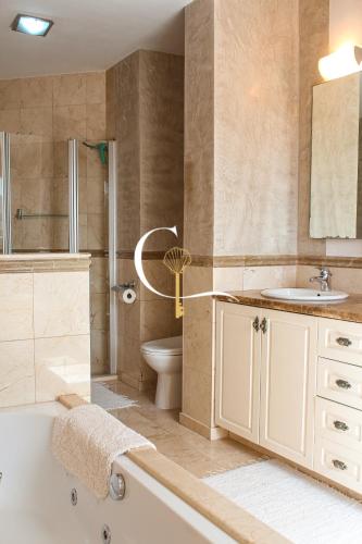 a bathroom with a tub and a toilet and a sink at Casa Lucia in Palm-Mar