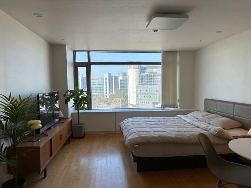 a bedroom with a bed and a large window at Self Check-in Only Residence near Incheon Airport T1 & Paradise City in Incheon