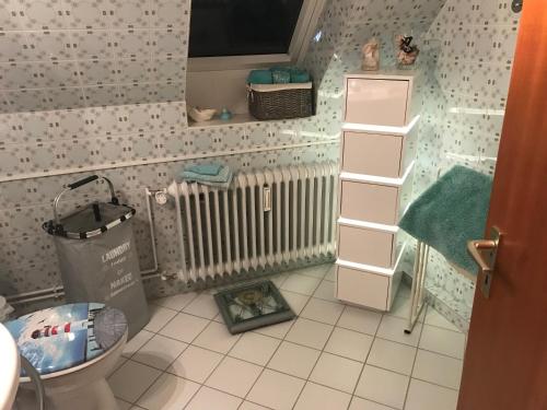 a small bathroom with a toilet and a radiator at Gemütliches Inselnest mit großer Terrasse nahe Nordsee& Hafen in Tönning