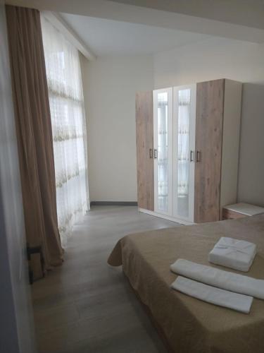 a bedroom with a bed with two towels on it at Квартира возле стадиона in Kobuleti