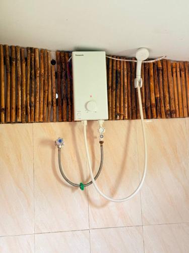 a shower with a hose attached to a wall at Sunny Bungalow in Koh Rong Sanloem