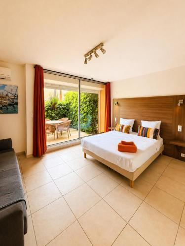 a bedroom with a large bed and a large window at Hôtel Le Maritime in Argelès-sur-Mer