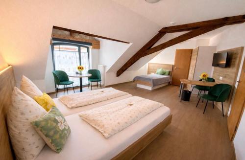a bedroom with two beds and a table and chairs at Hotel Zum Klosterfischer in Blankenburg