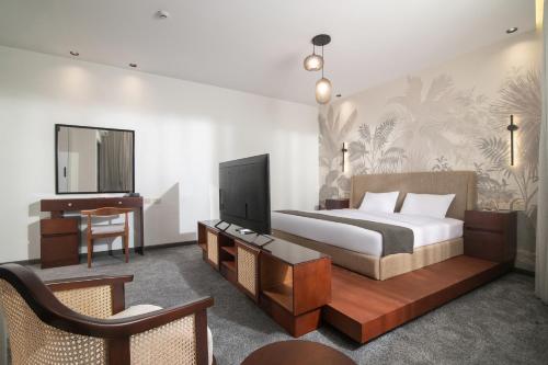 a bedroom with a bed and a desk and a television at Santino Boutique Hotel in El Alamein