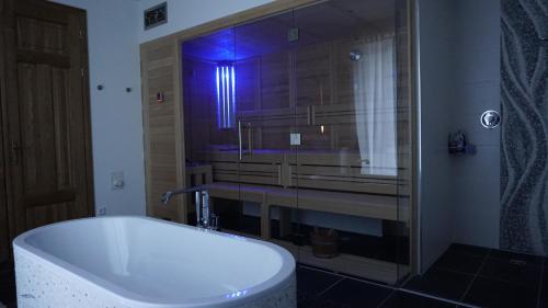 a bathroom with a tub and a shower and a sink at "Zweisam" am Scharmützelsee - Ferienwohnung mit mediterranem Charme in Diensdorf-Radlow