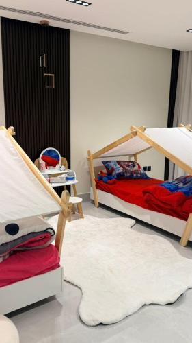 a bedroom with two bunk beds and a rug at منتجع شاطئ الدانة Hus Chalet in Dammam