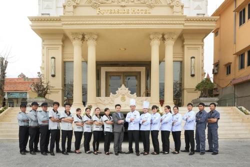 a group of men in uniform standing in front of a building at Riverside Hotel Quang Binh in Dong Hoi