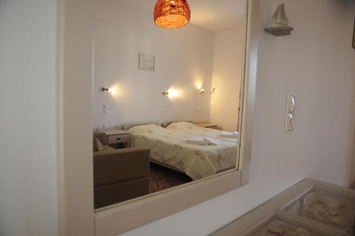 a mirror in a room with a bed and a couch at Andriani's Guest House in Mýkonos City