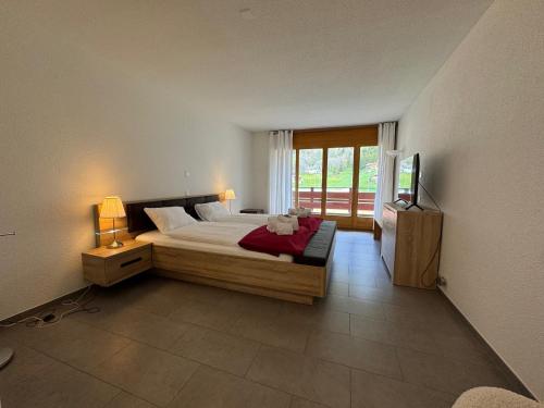 a bedroom with a bed and a television in it at Eiger Residence 1 in Wengen