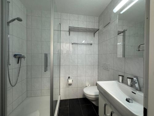 a bathroom with a shower and a toilet and a sink at Eiger Residence 1 in Wengen