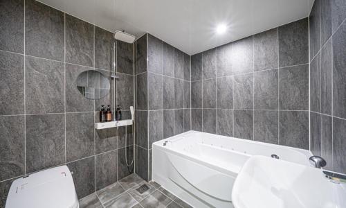 a bathroom with a tub and a toilet and a sink at BrownDot Hotel Bong-Duk in Daegu